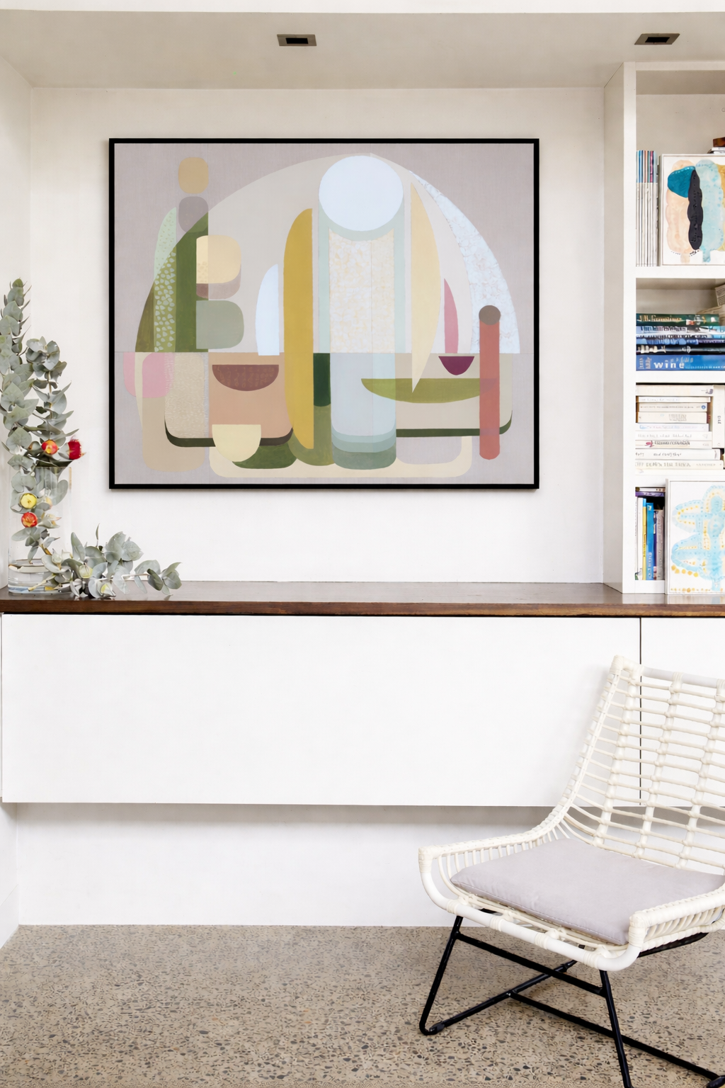 Modern interior with abstract art, bookshelf, and chair.