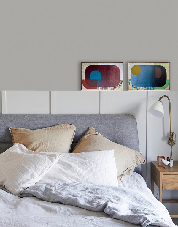 Bedroom with a bed featuring pillows and a headboard, with abstract art on the wall.