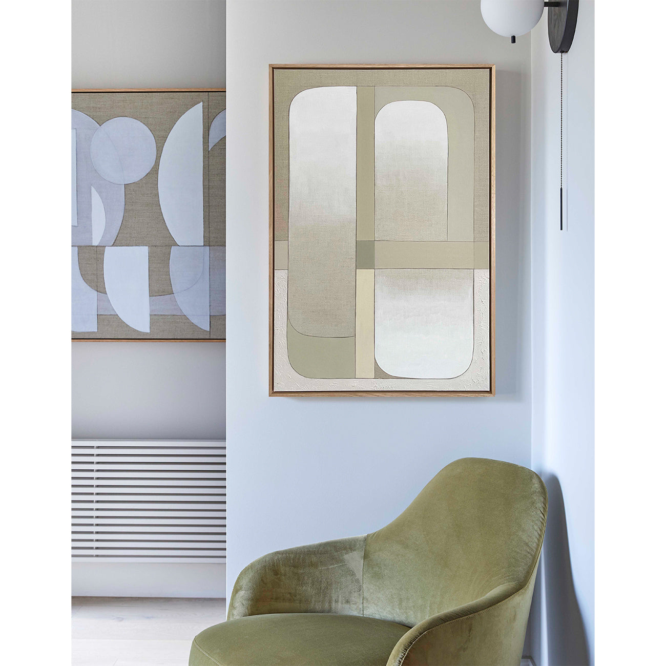 Modern interior with a green chair and abstract wall art in a minimalistic setting