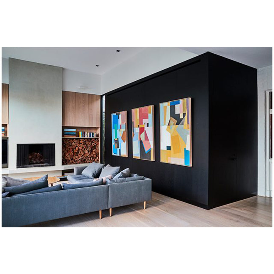 Modern living room with a black wall featuring extra large abstract paintings and a gray sofa.