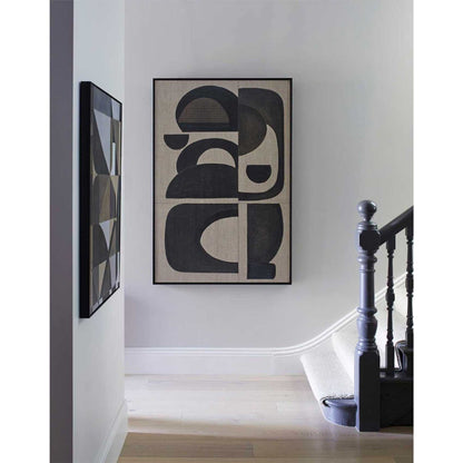 A framed abstract wall art print featuring abstract black geometric shapes on a wall in a home environment.