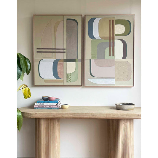 Studio Elwood “Olympia Diptych” — pair of abstract geometric artworks in muted sage, taupe, cream, and blush tones, framed in oak and styled above a sculptural timber console with art books and ceramic vessels.