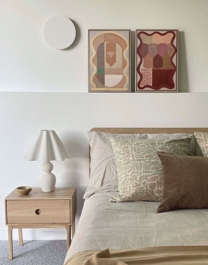 Modern bedroom with a bed, nightstand, and abstract wall art.