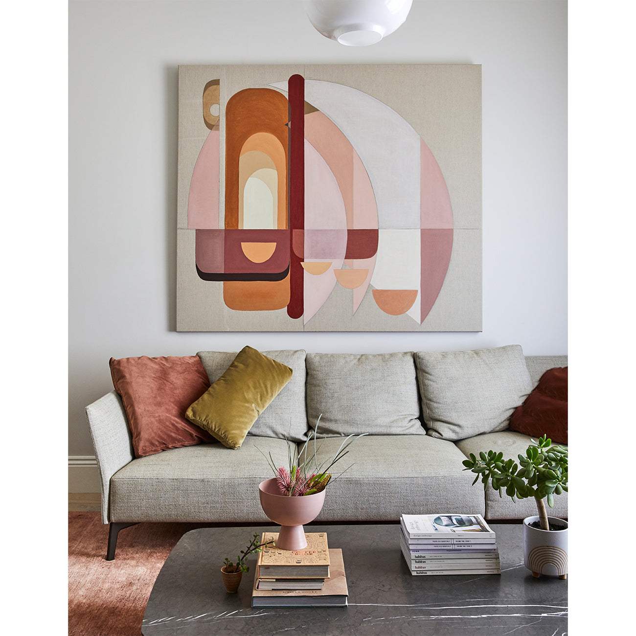 Framed Giclee print featuring abstract geometric artwork with a pink and beige color palette, displayed above a sofa in a living room setting.